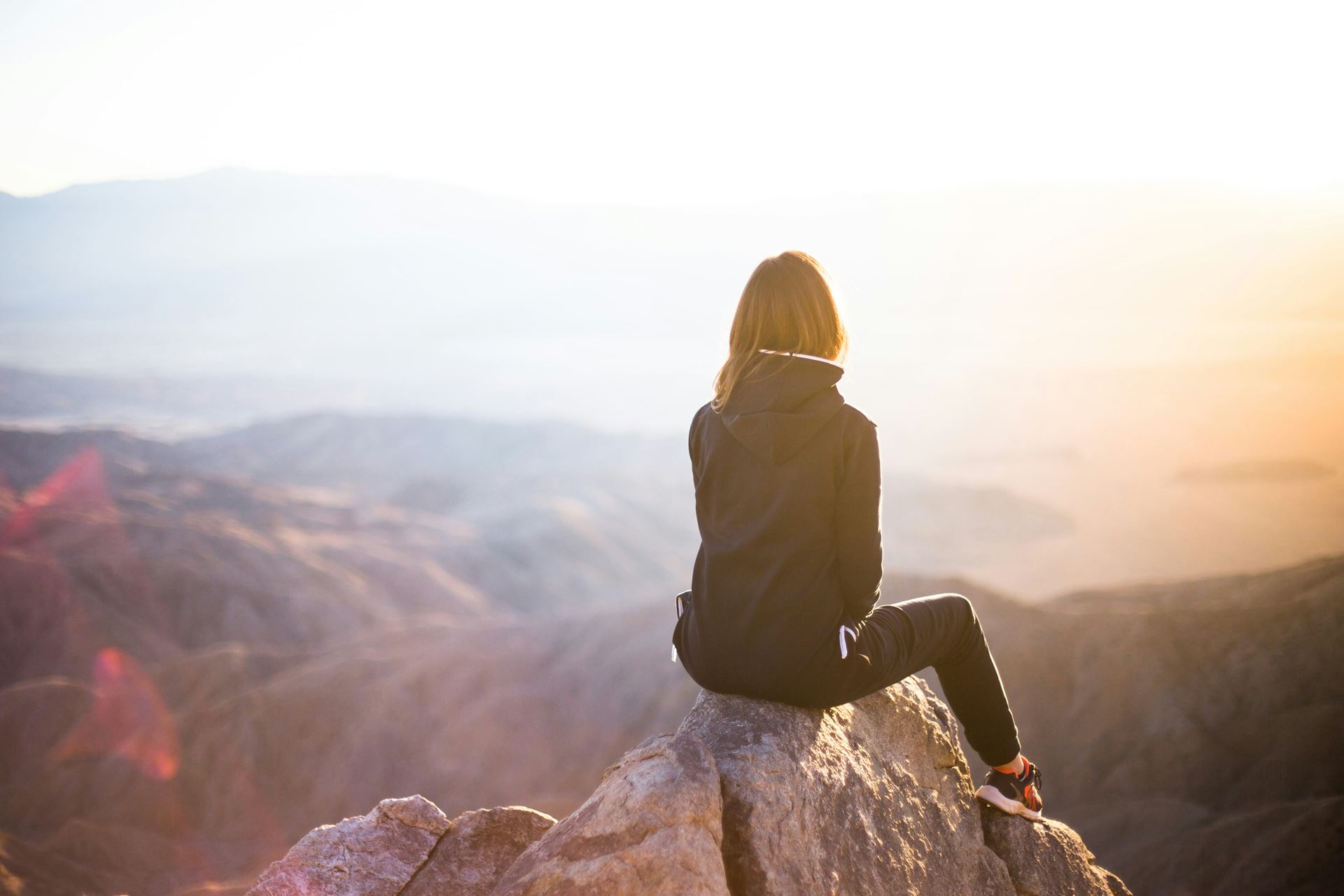 a woman looking down from the top of a hill