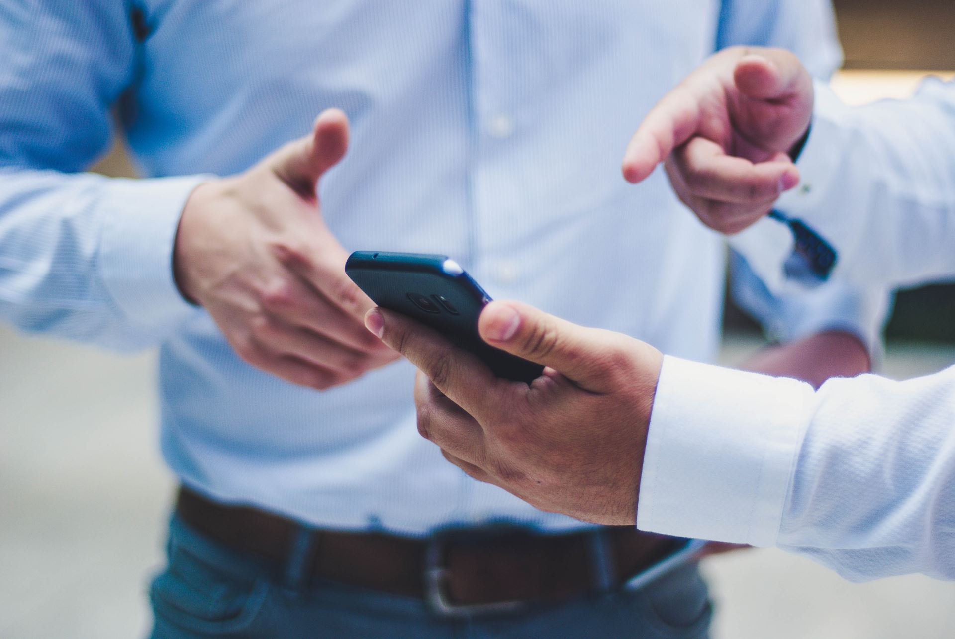 two men looking at a mobile phone