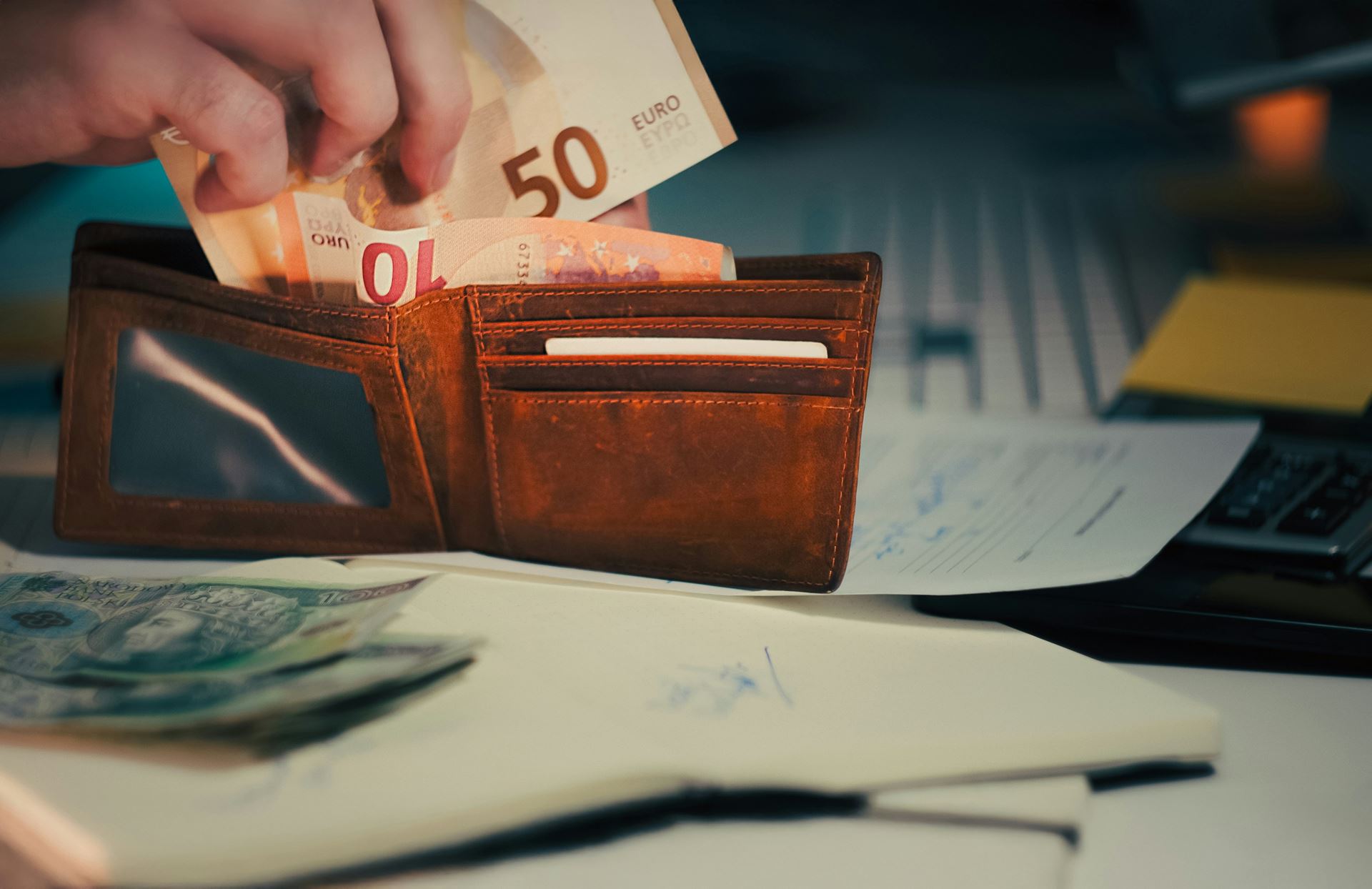 a person taking money out of a wallet